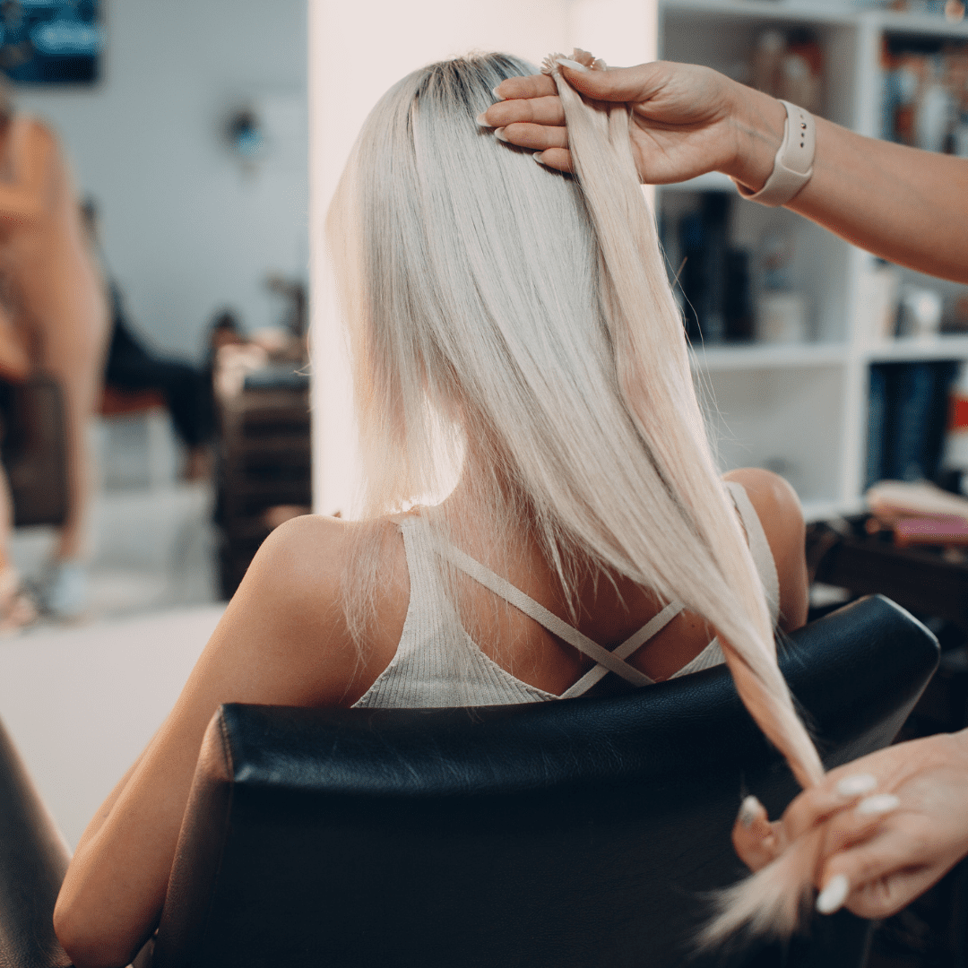 woman with blonde dyed hair sitting in salon chair