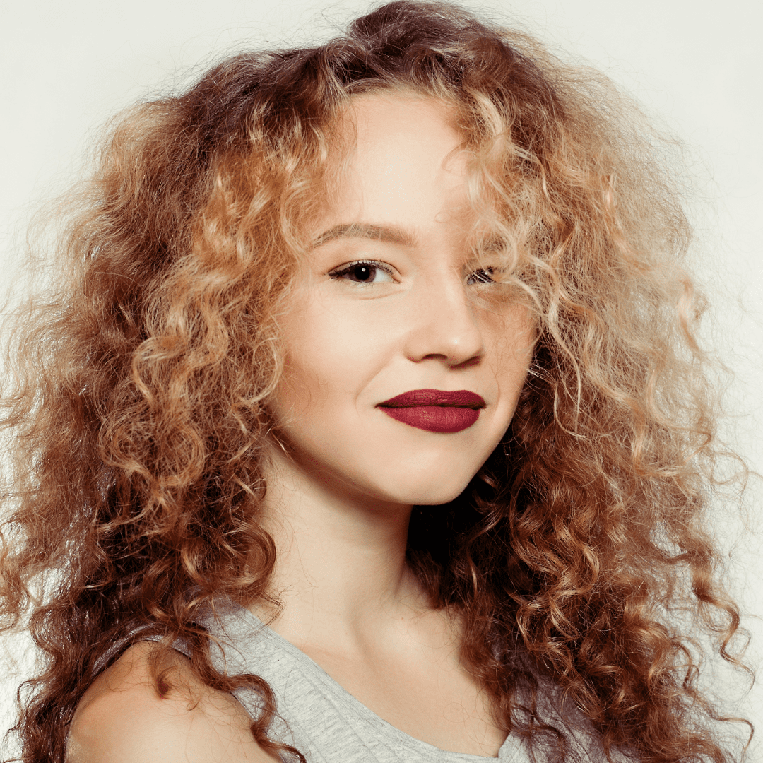 woman with permed bright hair and red lips smiling