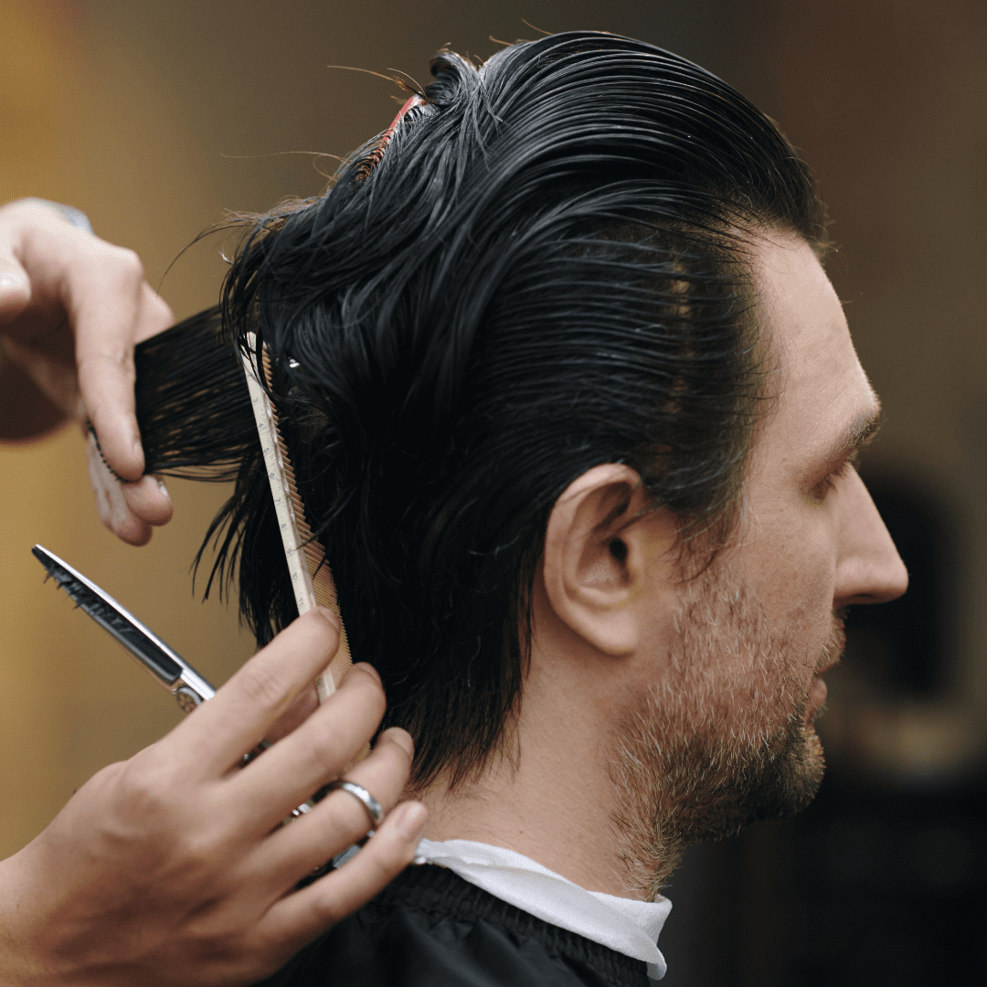 man with medium length dark hair getting haircut scaled down