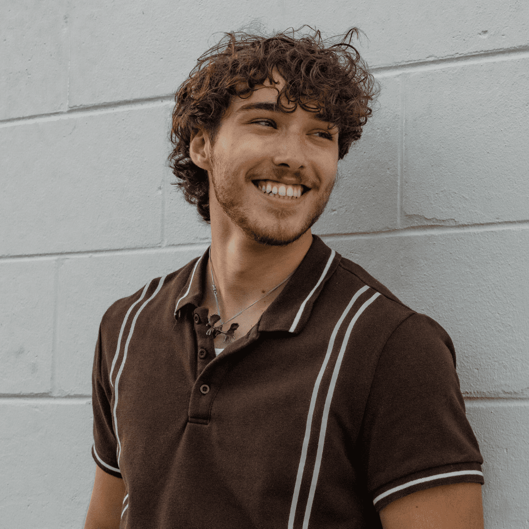 man with curly blonde hair smiling